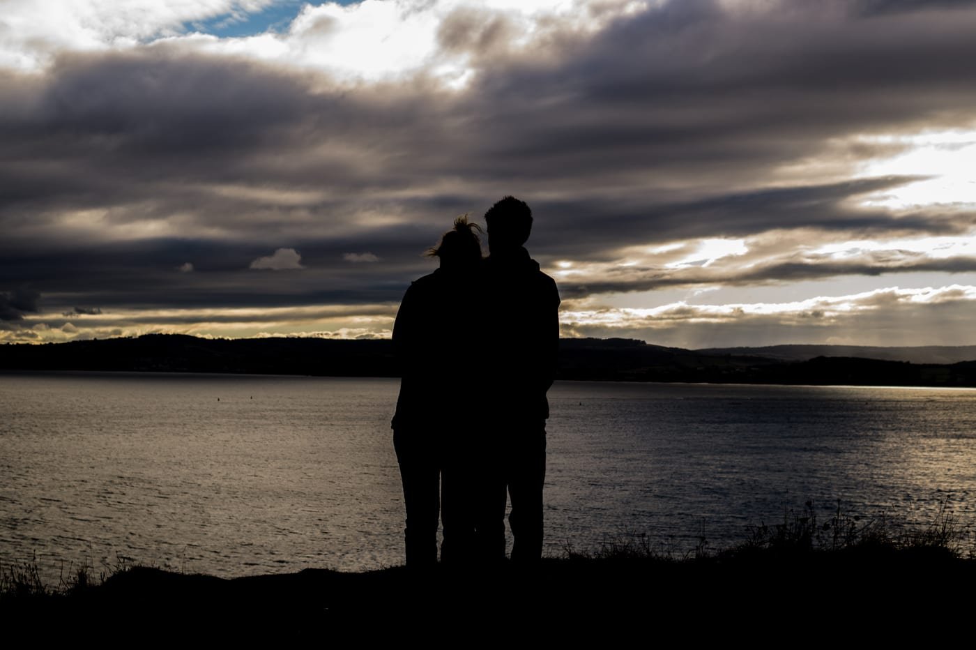Romantic couple silhouette embracing against a vibrant West Texas sunset horizon in Midland